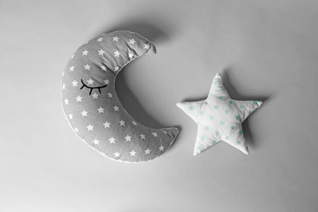 Soft decorative pillows in shape of moon and star on light backgroundの写真素材