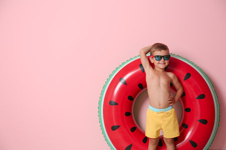 Cute little boy with inflatable ring on color backgroundの写真素材