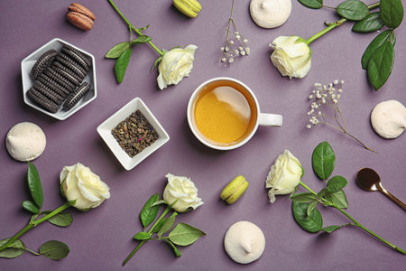 Flat lay composition with cup of tea, flowers and cookies on dark backgroundの写真素材