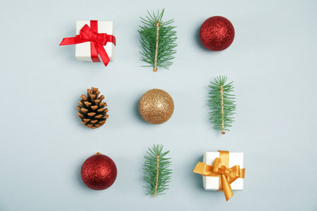 Flat lay composition with Christmas tree branches, decor and gift boxes on gray backgroundの写真素材