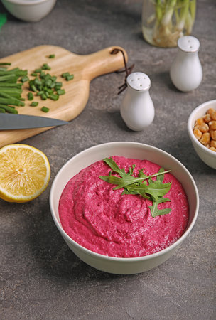 Bowl with tasty creamy beet hummus on dark tableの写真素材