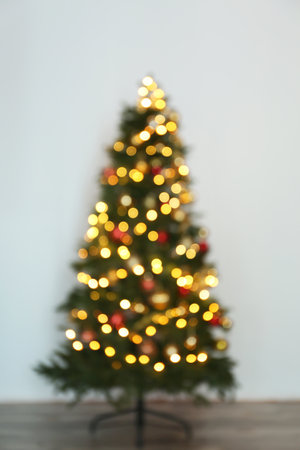 Blurred view of beautiful Christmas tree with fairy lights, indoorsの写真素材