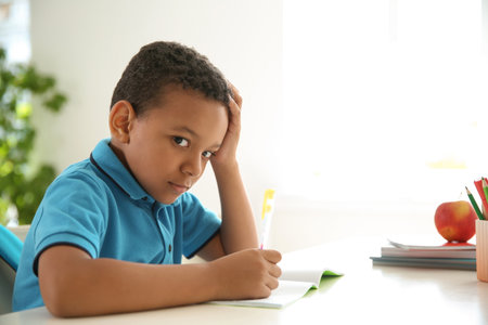 Cute little child doing assignment at desk in classroom. elementary schoolの写真素材