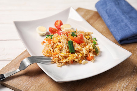 Plate with tasty boiled rice and vegetables on tableの写真素材