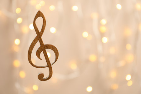 Wooden treble clef against blurred lights. christmas music conceptの写真素材