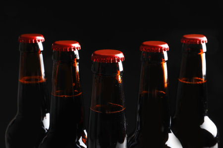 Bottles of tasty cold beer on black background, closeupの写真素材