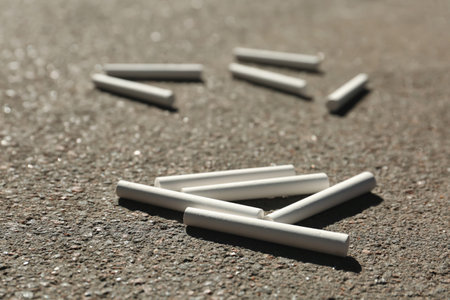 Many white chalk sticks on asphalt, closeupの写真素材