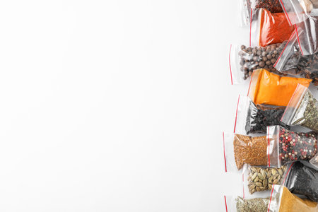 Plastic bags with different spices on white background, top viewの写真素材