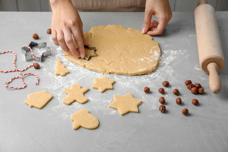 Young woman preparing Christmas cookies on tableの写真素材