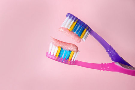 Toothbrushes with paste on color background, closeup