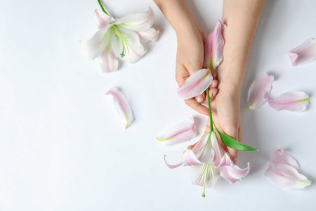Woman with beautiful lily flower on white background, top viewの写真素材