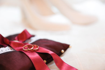 Decorative pillow with wedding rings on light background, closeupの写真素材