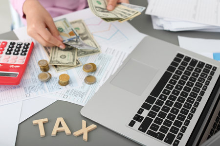 Young female calculating taxes at table, closeup