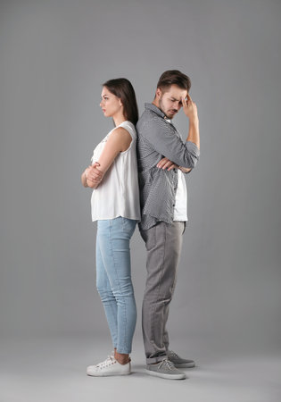 Upset young couple on gray background. relationship problemsの写真素材