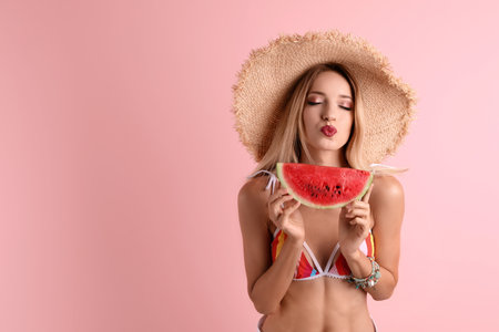 Pretty young woman with juicy watermelon on color backgroundの写真素材