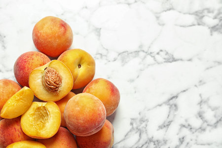 Pile of delicious ripe peaches on marble background, top viewの写真素材