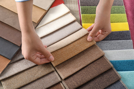 Young woman choosing among upholstery fabric samples, closeup. interior designの写真素材