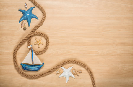 Flat lay composition with small boat and rope on wooden background. beach objectsの写真素材