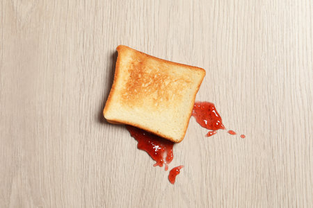 Overturned toast bread with jam on floor, top viewの写真素材