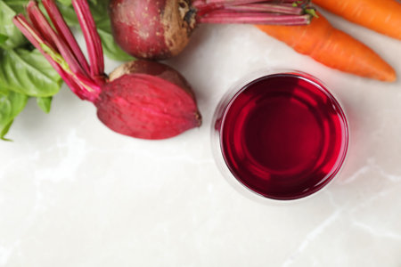 Glass with fresh beet juice and ingredients on table, top viewの写真素材