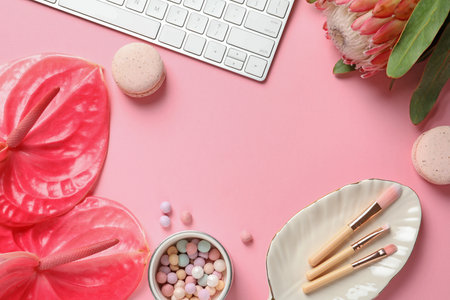 Creative flat lay composition with tropical flowers, computer keyboard and beauty accessories on color backgroundの写真素材