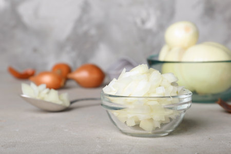 Glass bowl with cut onion on tableの写真素材