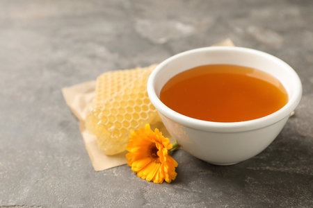 Composition with bowl of tasty fresh honey on tableの写真素材