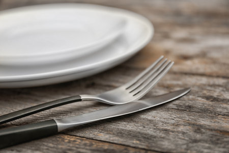 Empty dishware and cutlery on wooden table, close up view. Table settingsの写真素材