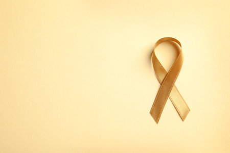 Gold ribbon on color background, top view. cancer awarenessの写真素材