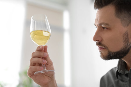 Man with glass of delicious wine indoorsの写真素材
