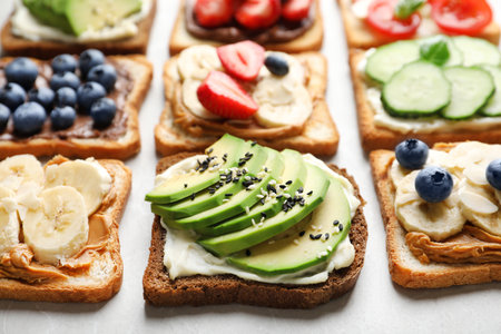 Tasty toast bread with fruits, berries and vegetables on light background, closeupの写真素材