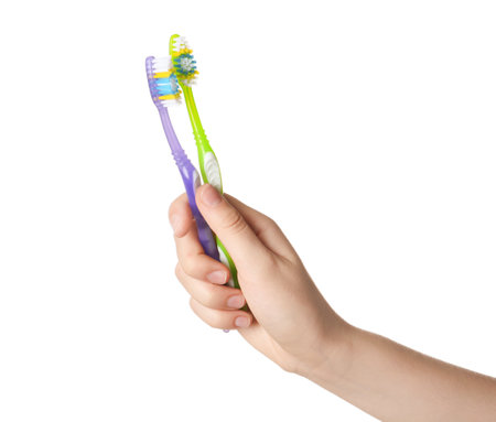 Woman holding manual toothbrushes against white backgroundの写真素材