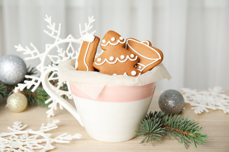 Cup with tasty homemade Christmas cookies on table