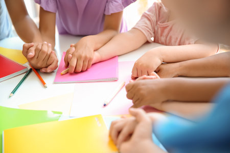Little children holding hands at table, closeup. unity conceptの写真素材