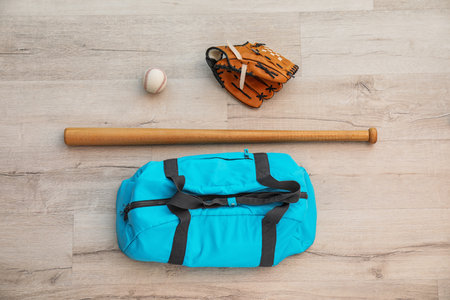 Sports bag, baseball ball and bat on wooden floor, top viewの写真素材