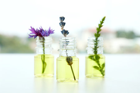 Composition with essential oils and flowers on tableの写真素材