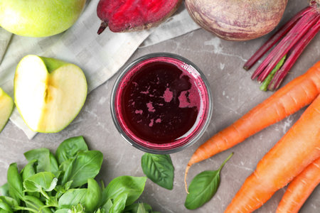 Glass of fresh juice and ingredients on table, top viewの写真素材