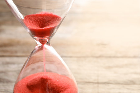 Hourglass with flowing sand on table, closeup. time managementの写真素材
