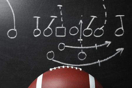 Leather American football on chalkboard with scheme of game, closeupの写真素材