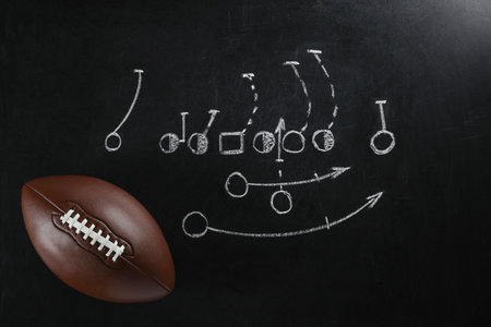 Leather American football on chalkboard with scheme of game, top viewの写真素材