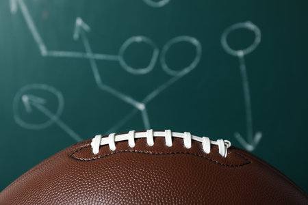 Leather American football on chalkboard with scheme of game, closeupの写真素材