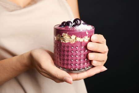 Woman holding glass with tasty acai smoothie, closeupの写真素材