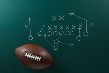 Leather American football on chalkboard with scheme of game, top viewの写真素材