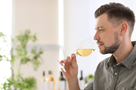 Young man with glass of wine indoorsの写真素材