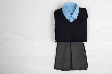 School uniform for girl on white wooden background, top viewの写真素材