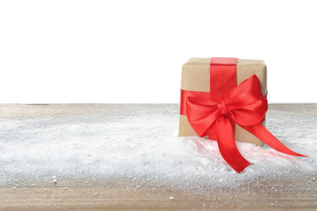Christmas gift box and snow on table against white backgroundの写真素材
