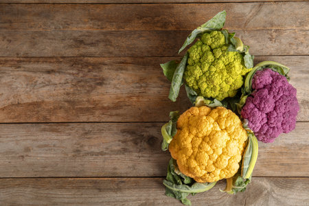 Colorful cauliflower cabbages on wooden table, top view. healthy foodの写真素材