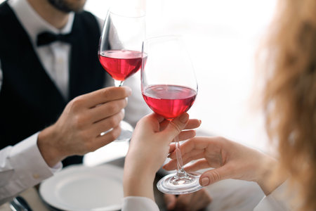Young couple with glasses of delicious wine in a restaurantの写真素材