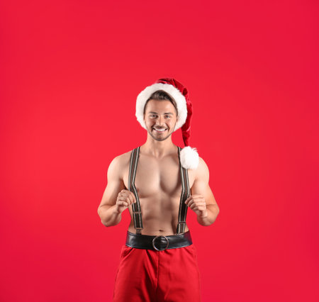 Shirtless young Santa Claus with sexy body on color backgroundの写真素材