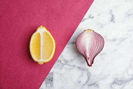 Beautiful composition with ripe red onion and lemon on color backgroundの写真素材